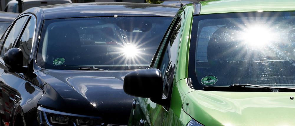 Sonne scheint auf parkende Autos.