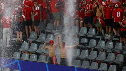 Die dänischen Fans werden auf der Tribüne vom Regen überrascht.