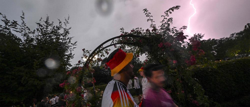 Ein Blitz schlägt ein, als deutsche Fans in der Fanzone und im Public-Viewing-Bereich des Westfalenparks in Dortmund am 29. Juni 2024 während des UEFA-Euro-2024-Achtelfinalspiels zwischen Deutschland und Dänemark Schutz vor einem Sturm suchen.