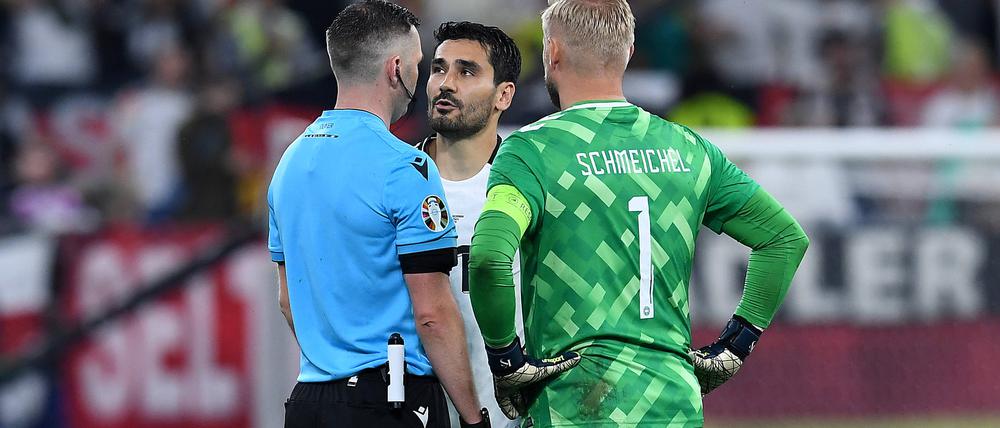 Schiedsrichter Michael Oliver erklärte den Kapitänen, warum es vor der zweiten Hälfte zunächst nicht weiterging.