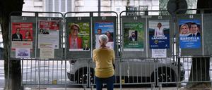 Eine Frau betrachtet Wahlplakate neben einem Wahllokal während der ersten Runde der Parlamentswahlen in Pau im Südwesten Frankreichs. 