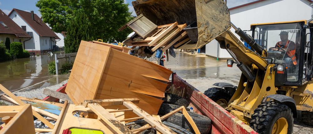 Im Bauhof wird mit einem Radlader der durch Hochwasser entstandene Sperrmüll in einen Container gekippt. 