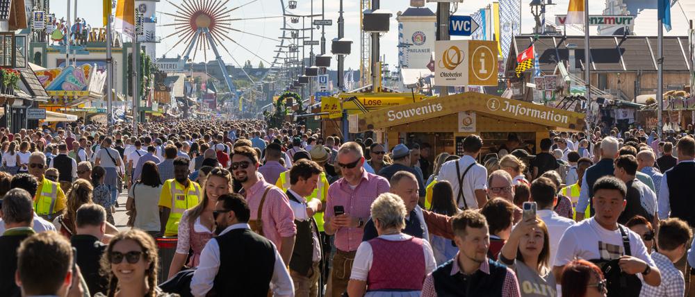 Wiesn-Besucher gehen 2023 über das Gelände.