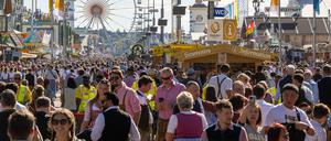 Wiesn-Besucher gehen 2023 über das Gelände. 