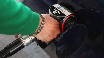 Ein Mann tankt sein Auto mit Diesel auf.