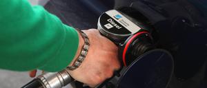 Ein Mann tankt sein Auto mit Diesel auf.