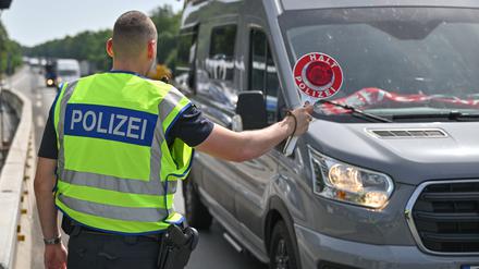 Ein Bundespolizist steht auf der Autobahn A12 nahe dem deutsch-polnischen Grenzübergang und stoppt ein Auto bei der Einreise nach Deutschland.