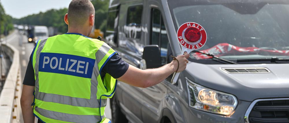 Ein Bundespolizist steht auf der Autobahn A12 nahe dem deutsch-polnischen Grenzübergang und stoppt ein Auto bei der Einreise nach Deutschland.