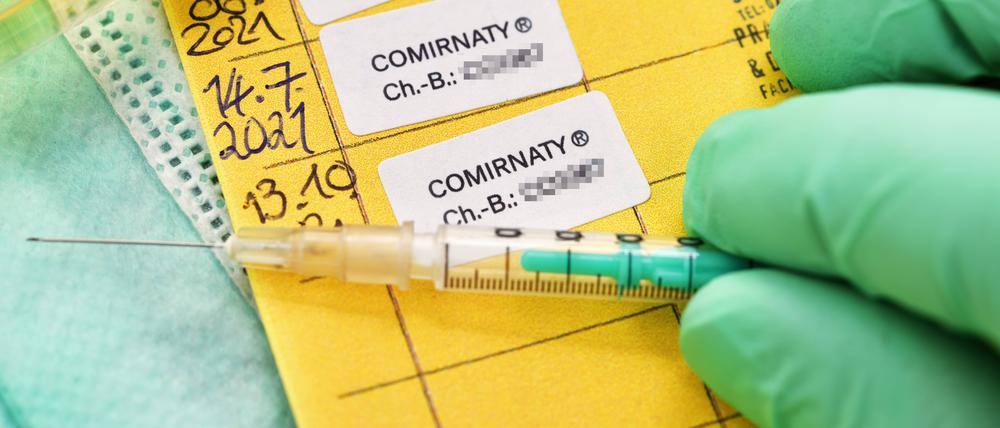 Impfpass mit drei eingetragenen Corona-Impfungen