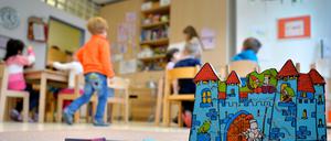 Kleinkinder spielen zusammen in einer Kita. Bauklötze und ein Spielzeugschloss stehen in dem Raum.