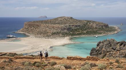 Touristen gehen mit Blick auf den Strand von Balos und seine Lagune im nordöstlichen Teil der Insel Kreta entlang (Symbolbild).