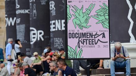 Besucher der Documenta Fifteen in Kassel sitzen auf den Stufen des Fridericianums.