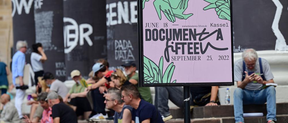 Besucher der Documenta Fifteen in Kassel sitzen auf den Stufen des Fridericianums.