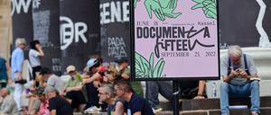 Besucher der Documenta Fifteen in Kassel sitzen auf den Stufen des Fridericianums.