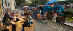 Kinder essen vor dem Kinderladen „Cuvrybande“ zu Mittag.