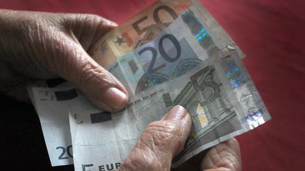 Eine Frau hält verschiedene Euronoten in der Hand. 