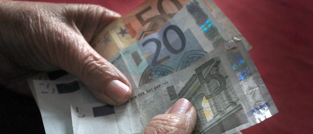 Eine Frau hält verschiedene Euronoten in der Hand. 