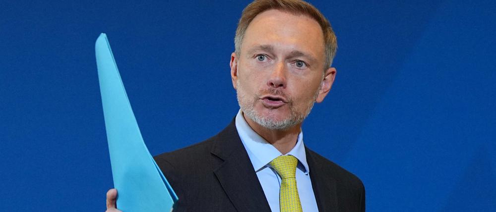 Christian Lindner (FDP), Bundesminister der Finanzen, winkt nach der Pressekonferenz zum Ergebnis der Steuerschätzung mit einem blauen Hefter.