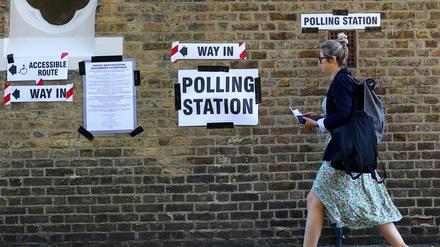 A woman walks by a polling station during the general election in London, Britain, July 4, 2024. REUTERS/Hannah McKay
