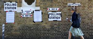 A woman walks by a polling station during the general election in London, Britain, July 4, 2024. REUTERS/Hannah McKay