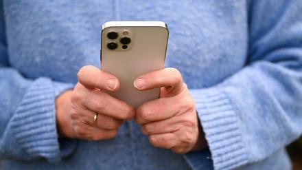 Eine Frau tippt auf ihrem Smartphone.