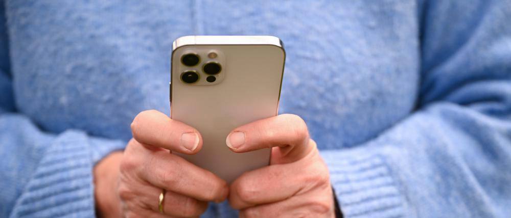 Eine Frau tippt auf ihrem Smartphone.