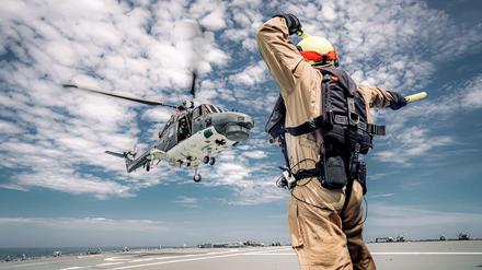 Der Flight Deck Officer weist die Crew des Bordhubschraubers „Sea Lynx“ beim Start vom Flugdeck der Fregatte „Baden-Württemberg“ ein.