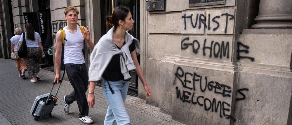 In Barcelona ist der Unmut gegen den Tourismus groß. „Tourist, geh nach Hause. Geflüchtete willkommen“ steht auf dieser Hauswand.