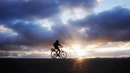 Ein Radfahrer fährt bei Sonnenuntergang auf dem Tempelhofer Feld (Archiv). 