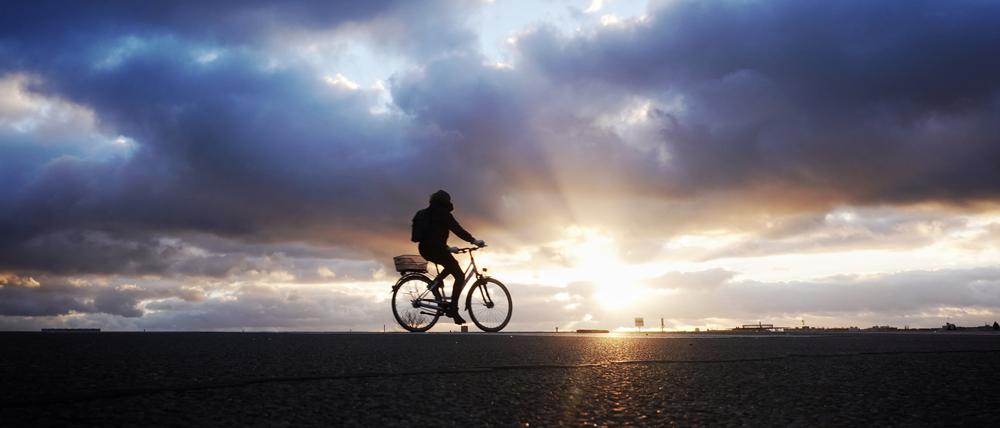 Ein Radfahrer fährt bei Sonnenuntergang auf dem Tempelhofer Feld (Archiv).