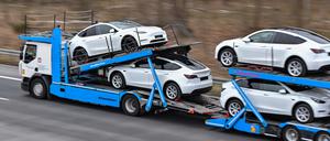 Grünheide: Neue Elektrofahrzeuge vom Typ Model Y werden mit einem Lkw vom Tesla-Werk abgeholt. 