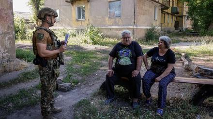 Iwan, 35, ukrainischer Polizist, überzeugt Serhij, 65, und Iryna, 54, Anwohner, die sich weigern, evakuiert zu werden, ihre Meinung zu ändern und die Stadt zu verlassen.