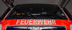 Ein Einsatzwagen der Berliner Feuerwehr mit eingeschaltetem Blaulicht steht in der Fahrzeughalle.