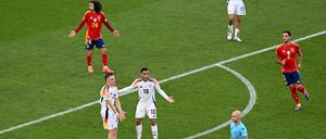 Deutschlands Jamal Musiala und Florian Wirtz reklamieren nach einem Handspiel von Spaniens Marc Cucurella bei Schiedsrichter Anthony Taylor aus England.
