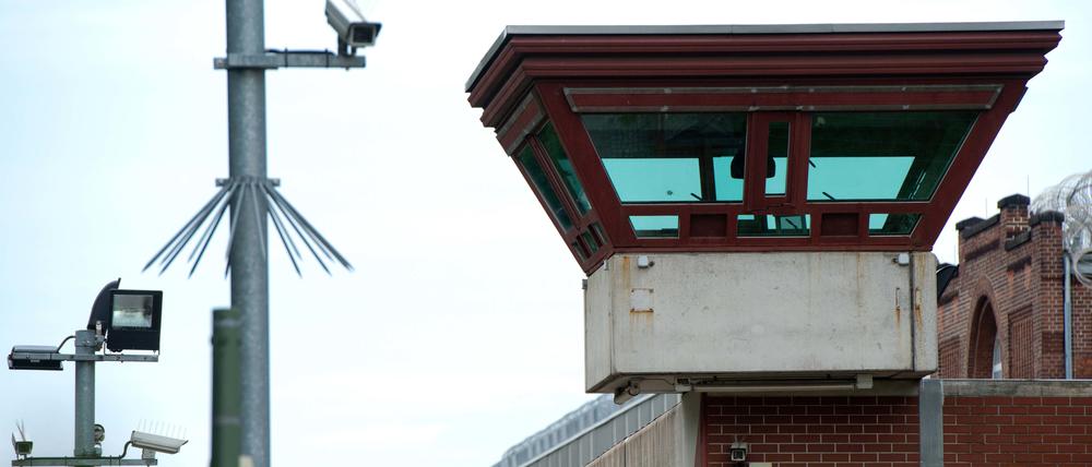 Ein Wachturm überragt die Außenmauer der JVA Tegel.