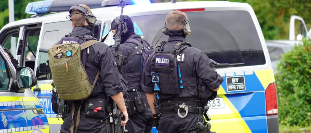 Einsatzkräfte der Polizei bereiten sich neben ihren Fahrzeugen auf den Einsatz vor. In Altdorf bei Nürnberg ist die Polizei wegen Bränden und einer «Bedrohungslage» zu einem größeren Einsatz ausgerückt. Eine Person soll mit Schusswaffe unterwegs sein. 