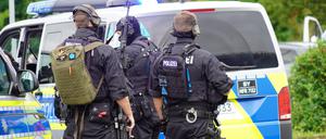 Einsatzkräfte der Polizei bereiten sich neben ihren Fahrzeugen auf den Einsatz vor. In Altdorf bei Nürnberg ist die Polizei wegen Bränden und einer «Bedrohungslage» zu einem größeren Einsatz ausgerückt. Eine Person soll mit Schusswaffe unterwegs sein. 