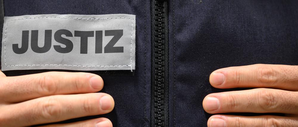 Ein Justizbeamter steht in einem Gerichtssaal des Landgerichts. (gestellte Szene)