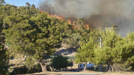 Firemen and helicopters try to control a large wildfire in Stamata. (June 30, 2024)