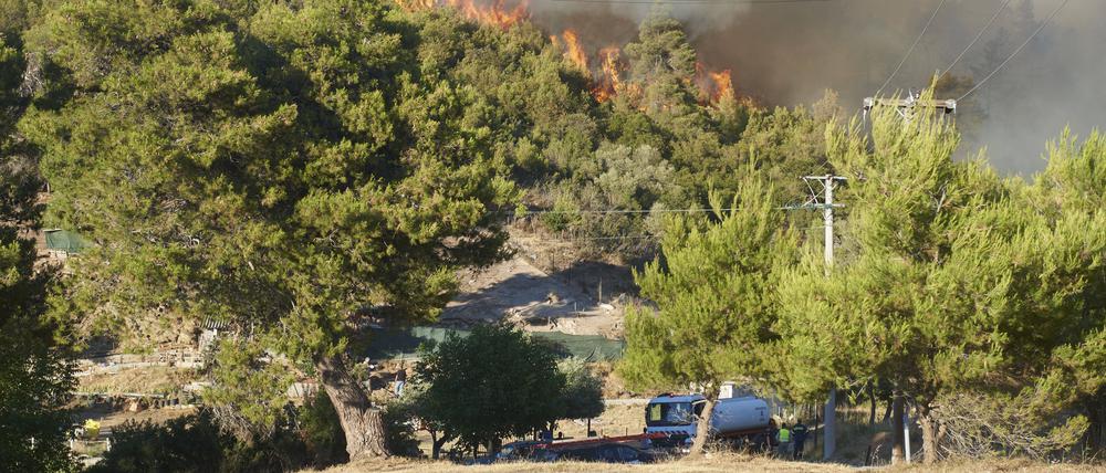 Firemen and helicopters try to control a large wildfire in Stamata. (June 30, 2024)
