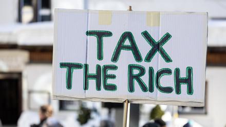 ARCHIV - 14.01.2024, Schweiz, Davos: Auf einem Schild steht «Tax the richt». (zu dpa: «Umfrage: Mehrheit ist für Vermögenssteuer») Foto: Hannes P Albert/dpa +++ dpa-Bildfunk +++