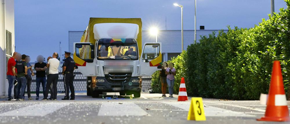 Polizisten und weitere Personen stehen neben einem Lastwagen. Ein 32-jähriger Lastwagenfahrer hat mit seinem Transporter in Österreich das Gebäude einer Pfingstkirche gerammt. 