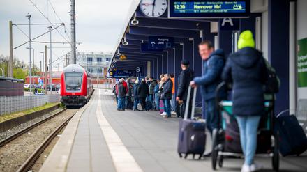 Fahrgäste warten in Norddeich-Mole in Niedersachsen auf einen einfahrenden Regionalzug.