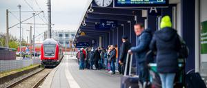 Fahrgäste warten in Norddeich-Mole in Niedersachsen auf einen einfahrenden Regionalzug.