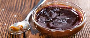 Barbeque Sauce with Tomatoes, Smoked Salt and fresh Herbs (on rustic wooden background)