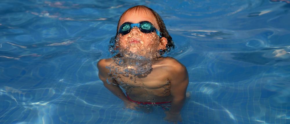 Ein Junge taucht im Wasser. Kommt er wieder hoch? Eltern müssen gut darauf achten.
