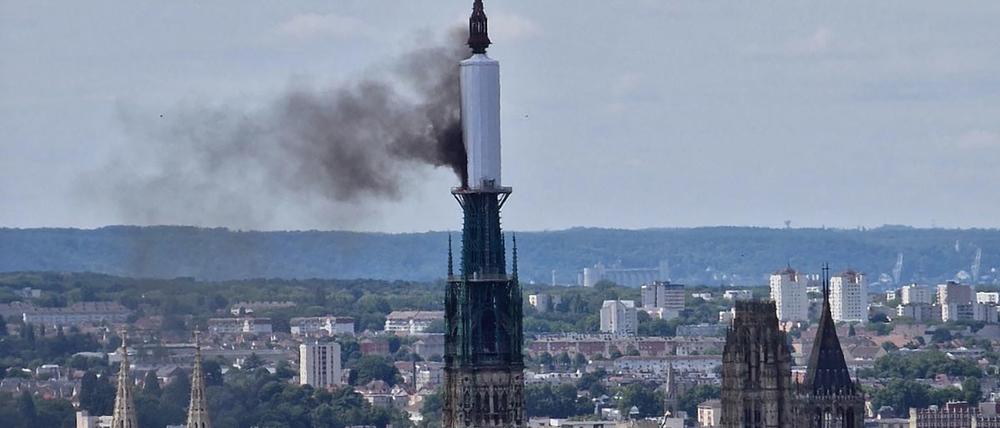 Vom Turm der Kathedrale von Rouen steigt eine Rauchwolke auf.