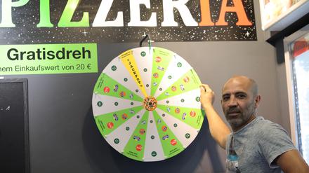 Pizzeria in der Brandenburger Straße Potsdam. Inhaber Selahattin Türgüt (Selo) steht am Glücksrad.