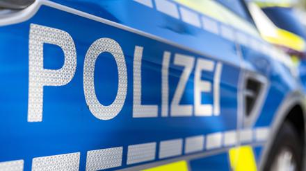 An der Tür von einem Streifenwagen steht der Schriftzug „Polizei“.