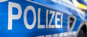 An der Tür von einem Streifenwagen steht der Schriftzug „Polizei“.